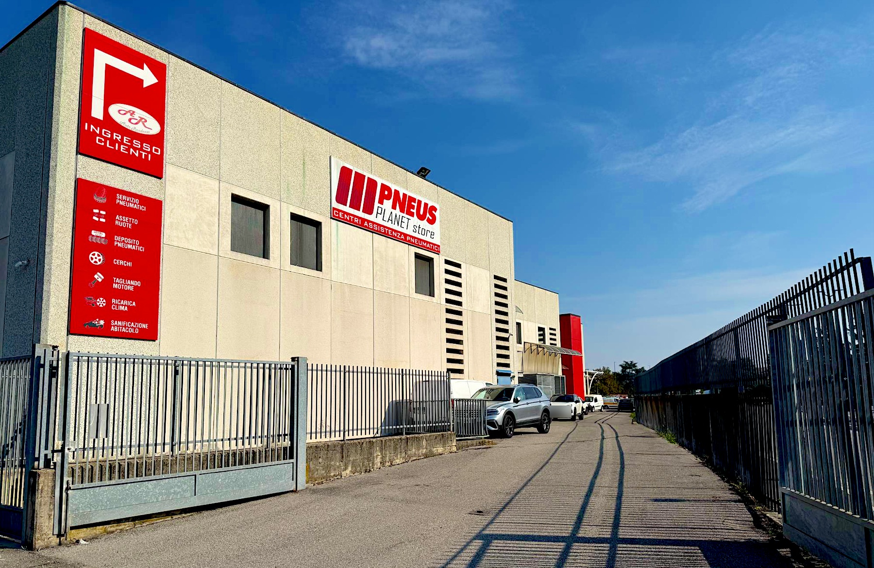 L'ingresso dell'officina con il cartello rosso Auto Randazzo Ingresso clienti e il cancello