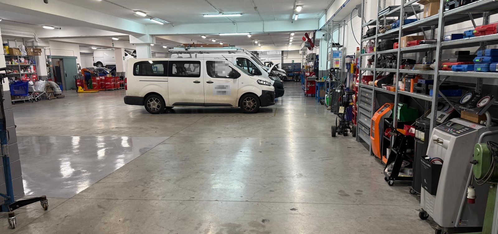 L'officina vista dall'ingresso, con i furgoni e le attrezzature sugli scaffali